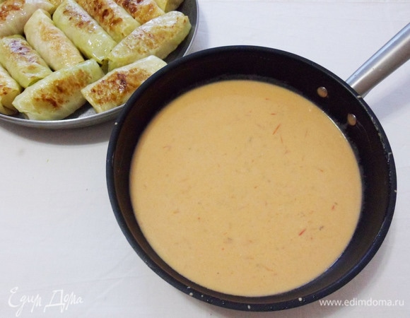 Перекладываем обжаренные голубцы в форму для запекания. В сковороду, где мы жарили голубцы, влить стакан воды, добавить муку, сметану, томатное пюре, соль по вкусу и дать соусу закипеть.