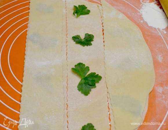 Затем накрывай сверху ближней полоской — и так остальные... Слегка прокатываем скалкой, соединяя тесто. Листочки получаютя внутри теста. Далее фарш выкладываем по центру листочка и смазываем промежутки желтком или водой с помощью кисточки, накрываем другим пластом теста и формируем равиоли, по краям проходимся вилкой или специальным кругом.  