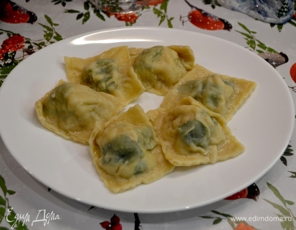 Готовые равиоли выложить в тарелку, оставляя в центре место для грибного соуса.