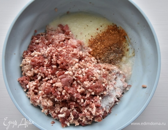 В мясной фарш выложить измельченный лук, соль, специи и воду. Хорошо перемешать. Фарш должен получиться более жидким по консистенции по сравнению с котлетным.