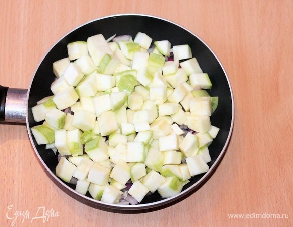 От кабачка отрезаем 6 небольших тонких кружочков — это для украшения верха запеканки. Остальную часть кабачка режем небольшими кубиками и кладем в сковороду, смешиваем с овощами (луком и чесноком). Накрываем сковороду крышкой и тушим на медленном огне до прозрачности лука, кабачок дойдет в духовке. Не забываем перемешивать. Солить самую малость, учитываем, что будет сыр и соевый соус.