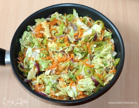 Добавьте капустную смесь, прессованный чеснок и по вкусу острый перец чили. Жарьте на среднем огне минут 10–15, периодически перемешивая.