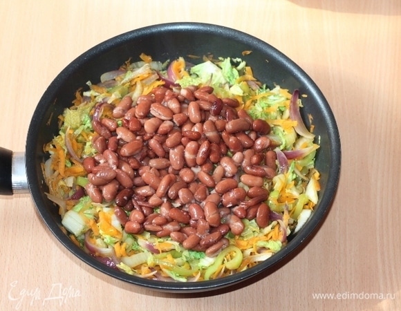 Добавьте вареную фасоль, сливочное масло, овощную приправу. Жарьте еще 5  минут. Жареная капуста с фасолью готова!