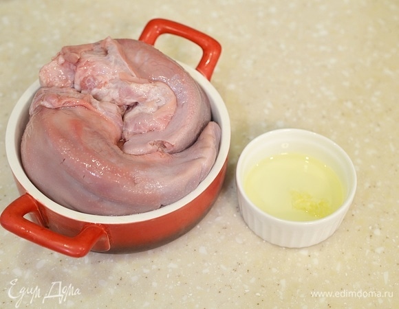 В жаропрочную форму выложите языки. Масло смешайте с измельченным чесноком. Полейте этой смесью языки.