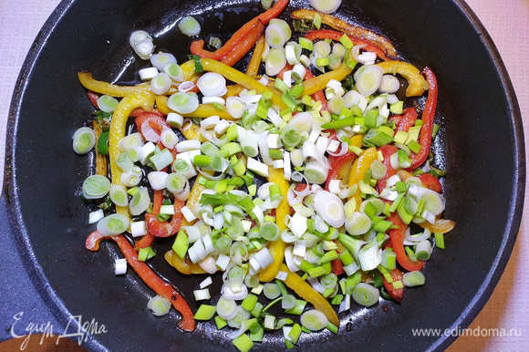 В этой же сковороде быстро обжариваем болгарский перец, перец чили и зеленый лук.