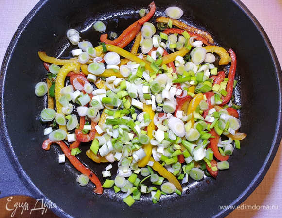 В этой же сковороде быстро обжариваем болгарский перец, перец чили и зеленый лук.
