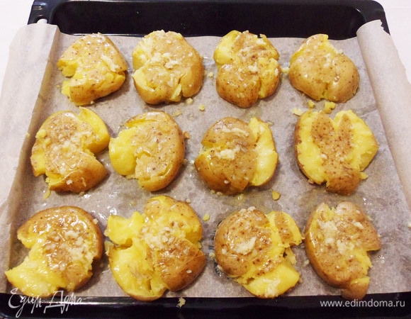 Кисточкой смазываем каждую картошку сливочным маслом с чесноком.