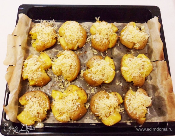 Достаем противень из духовки и посыпаем картошку натертым сыром, возвращаем в духовку еще на 5 минут.