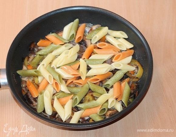 Смешать пасту с грибным соусом и довести на медленном огне до готовности.