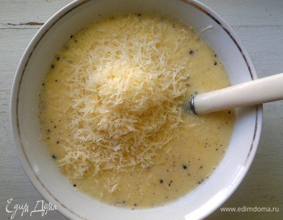 В заливку положить половину натертого сыра, перемешать.