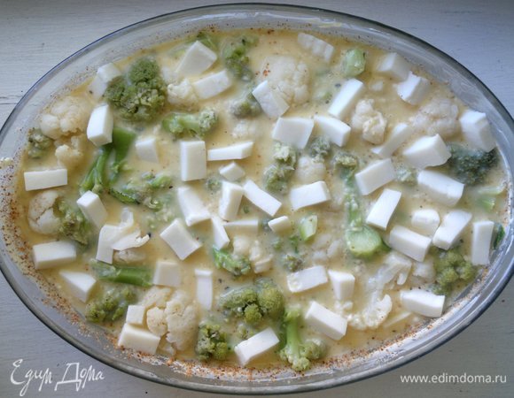 Вылить заливку в форму. Адыгейский сыр нарезать кубиками и разложить между соцветиями капусты.