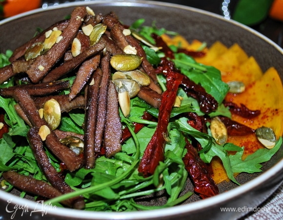 Руколу перемешайте с вялеными помидорами, приправьте все маслом из под вяленых помидоров (у меня очень ароматное масло с добавлением чеснока и базилика), посолите по вкусу. Говяжий язык положите сверху и посыпьте жареными тыквенными семечками. Приятного аппетита.