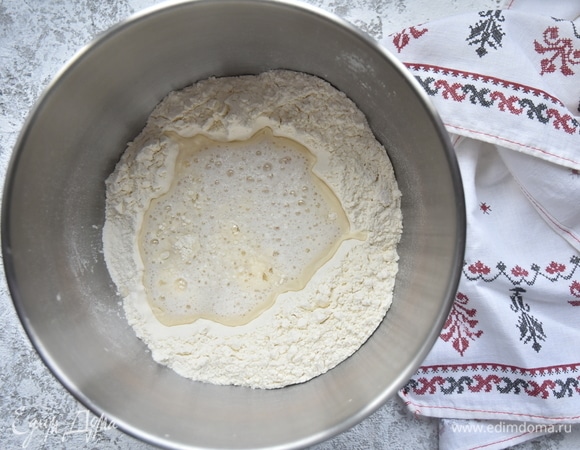 Соедините муку с жидкой частью и начните замешивать тесто.