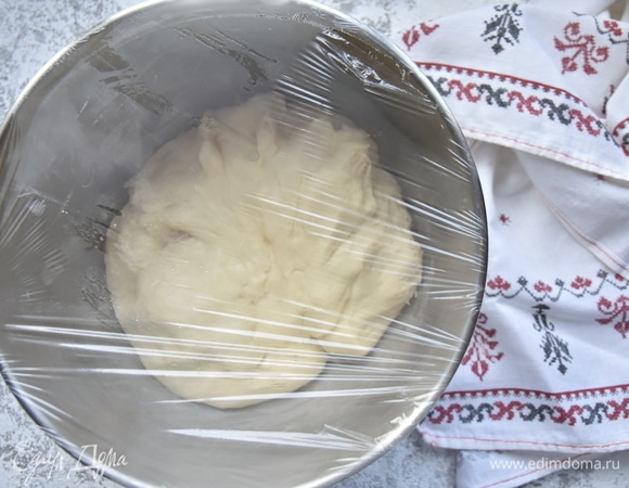 Стенки чаши смажьте небольшим количеством оливкового масла, выложите тесто и накройте его пищевой пленкой. Оставьте тесто для подъема на 30 минут.