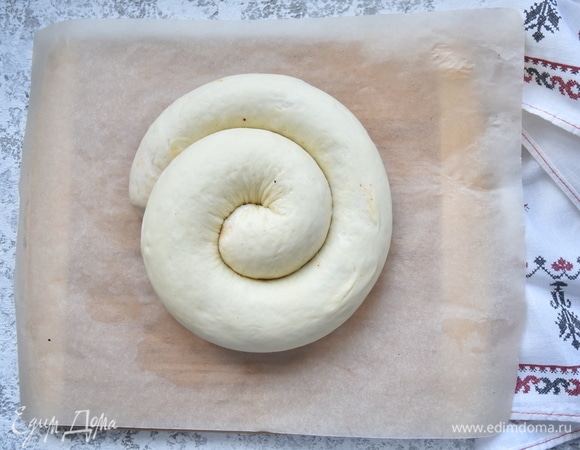 Скатайте тесто в плотный рулет, а затем сверните рулет улиткой. Дайте еще немного времени тесту отдохнуть. Смажьте небольшим количеством растительного масла и посыпьте сверху щепоткой крупной морской соли. Формировать улитку удобнее на бумаге для выпечки, чтобы легче перенести на противень.