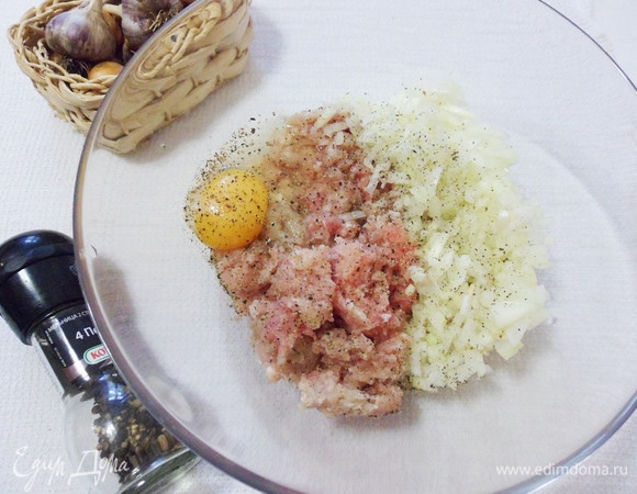 Мясной фарш переложить в миску. Добавляем мелко нарезанные лук и чеснок, одно яйцо, соль и черный молотый перец по вкусу. Хорошо перемешиваем.