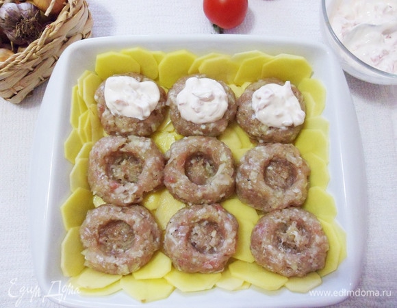 В мясных шариках делаем углубления и выкладываем сметану с помидорами.
