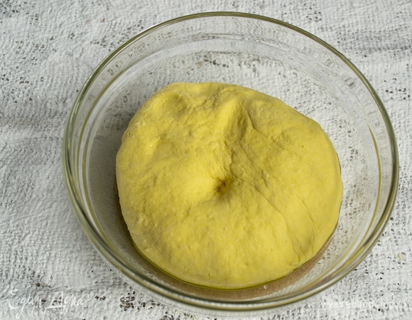 Смешиваем тесто ложкой, затем выкладываем на стол, месим 7–8 минут. Сначала будет клеится, постепенно соберется в ком.