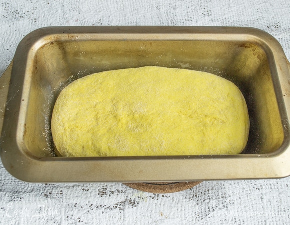Обминаем тесто, посыпаем кукурузной мукой, формуем хлебушек подходящей формы, кладем в форму.