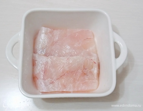 Возьмем форму, которую можно ставить в микроволновую печку, и смажем растительным маслом. Укладываем нашу рыбку. Если кусочек большой, лучше разрезать вдоль.
