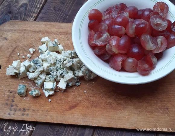 Виноград вымыть, удалить косточки. Крупные виноградины разрезать напополам. Сыр дорблю измельчить.