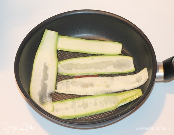 Отвариваем рис по инструкции. Кабачки промыть, обсушить бумажным полотенцем и пнарезать тонкими полосками. Обжарить кабачковые полоски на разогретом растительном масле. Готовые кабачковые полоски выкладываем на бумажную салфетку, чтобы убрать лишнее масло.