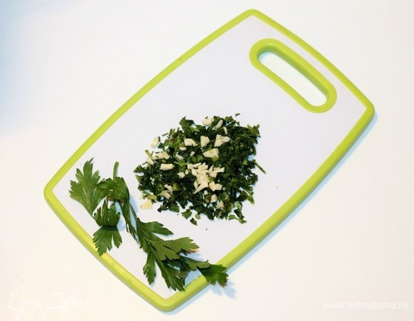 Приготовим заправку для риса. Моем и мелко режем петрушку и руками перетираем с маленькой щепоткой соли до выделения сока. Добавляем очищенный и нарезанный чеснок.