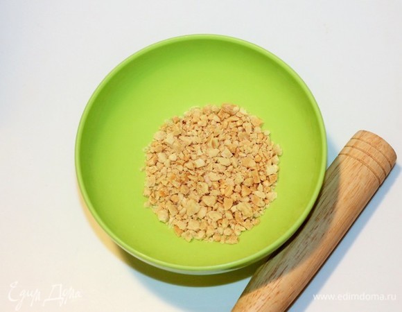 Очищенные и обжаренные на сухой сковороде орехи (на ваш вкус) измельчаем скалкой.