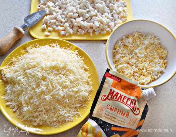 Яйца отварите, очистите от скорлупы и натрите на мелкой терке. Сыр так же натрите на мелкой терке. Очищенные кальмары доведите до кипения в соленой воде, воду слейте, кальмары нарежьте мелкими кубиками, слекга сбрызните лимонным соком.