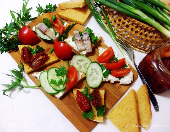 С томатным хлебом получаются очень вкусные бутерброды. Нарезаем хлеб треугольниками, смазываем сливочным творожным сыром, а сверху можно положить все, что любите: ломтики селедки, дольки помидора, кружки огурцов. Мне очень нравятся бутерброды с томатным хлебом и вялеными томатами. Приятного аппетита! Угощайтесь!