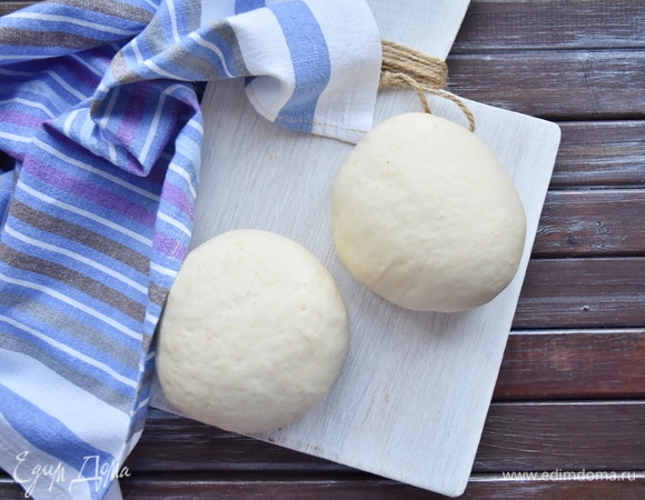 После того как тесто подойдет, разделить его на две равные части. Заготовки слегка округлить, стараясь не сильно их мять.