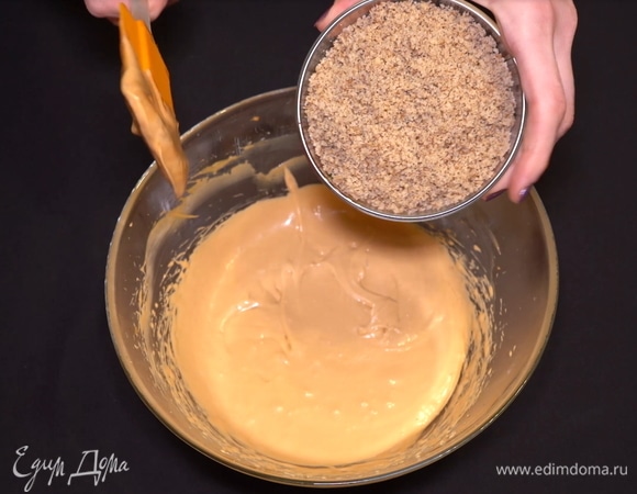 Измельчаем в мелкую крошку слегка обжаренные на сковороде грецкие орехи. Всыпаем их в получившийся крем. Не поленитесь их обжарить, пусть они раскроют свой неповторимый вкус и аромат.