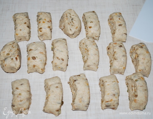 На посыпанной мукой поверхности выместите тесто, оно должно стать эластичным и однородным. Если нужно, добавьте еще муки. Раскатайте тесто в колбаску и разрежьте на ровные кусочки.