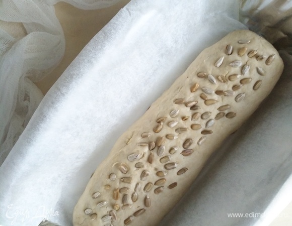 Из теста формируем наш хлеб, сверху посыпаем семечками подсолнечника. Выкладываем в форму или просто на пергаментную бумагу.