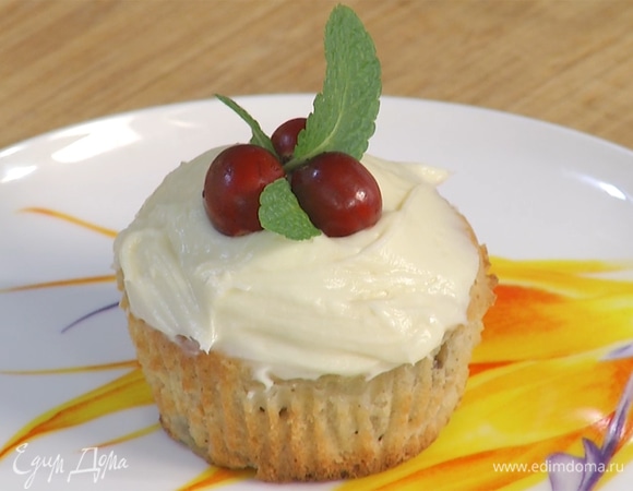 Готовым маффинам дать остыть, затем украсить кремом. Сверху дополнить ягодами клюквы и листьями мяты.