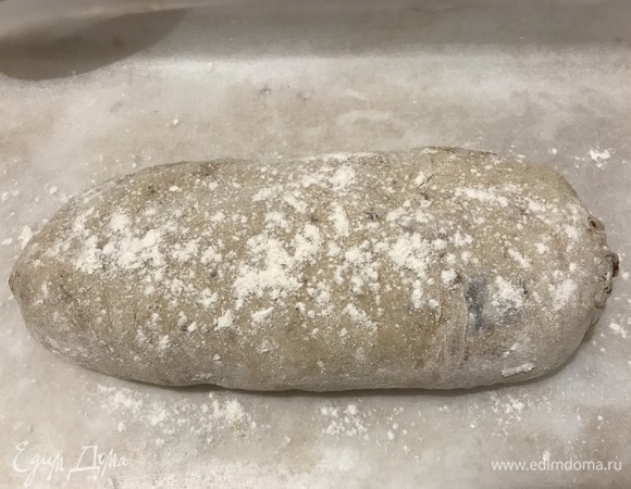 Подпылить рабочую поверхность мукой, выложить тесто, разделить его на 2 части. Сформировать 2 батона, посыпать их мукой.