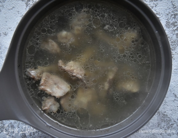Так как для приготовления супа использовала бедра, я предварительно освободила мясо от костей. Можно сразу нарезать его порционными кусочками или сделать это после отваривания. Косточки и мясо хорошо промыть, залить водой и поставить на небольшой огонь варить бульон, снимая образующуюся пену. Через 40 минут бульон процедить, косточки удалить, а мясо отложить.
