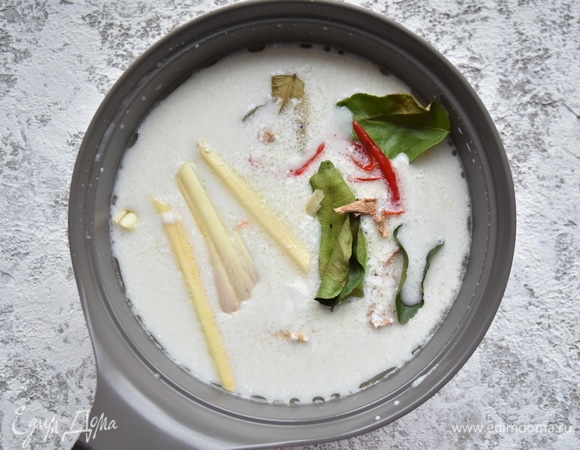 В подготовленный бульон влить кокосовое молоко, выложить лемонграсс, листья каффир-лайма, корень галангала, перец чили. Дать бульону закипеть и варить минут 5–7 на медленном огне. После отваривания их можно удалить из бульона. Добавить отложенные кусочки отварной курицы, грибы, помидоры. Варить еще 5 минут. В конце влить рыбный соус, добавить тростниковый сахар по вкусу, цедру и сок лайма.