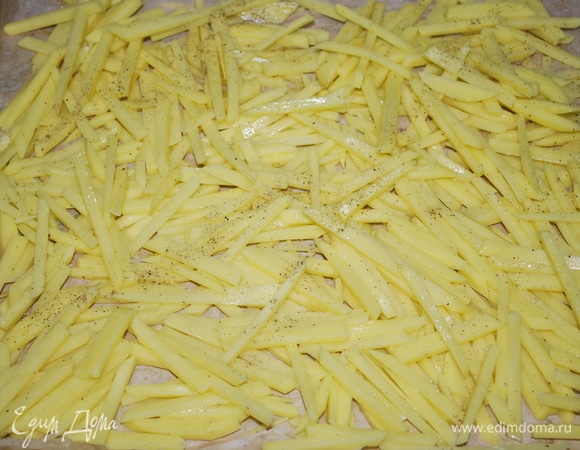 Очистите картофель и нарежьте тонкими брусками (тоньше, чем на картофель фри). Выложите на противень и запекайте в духовке 20 минут.