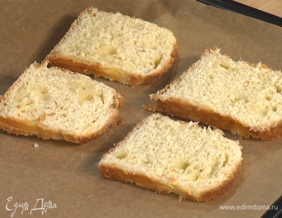 Нарезать тонкими кусками сдобную булку. Застелить противень пергаментом, выложить куски булки, поставить в духовку на 3–5 минут подсушиться.  