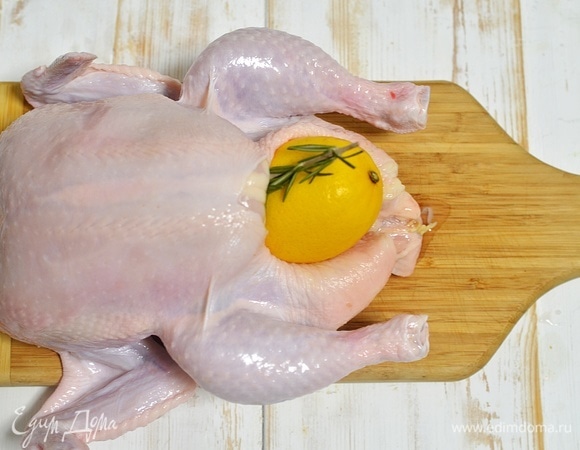 Воду слейте, курицу обсушите. Вовнутрь курицы положите лимон и любые травы по желанию. У меня — розмарин. Но это может быть и тимьян, и мята, и базилик.