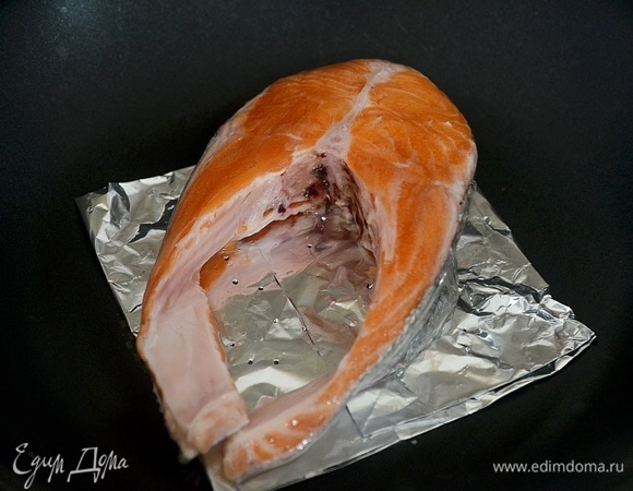 На сковороду положите квадрат из фольги отверстиями вверх, на него — рыбу.