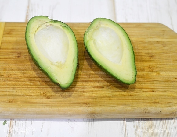 Авокадо разрежьте пополам вдоль и удалите косточку.