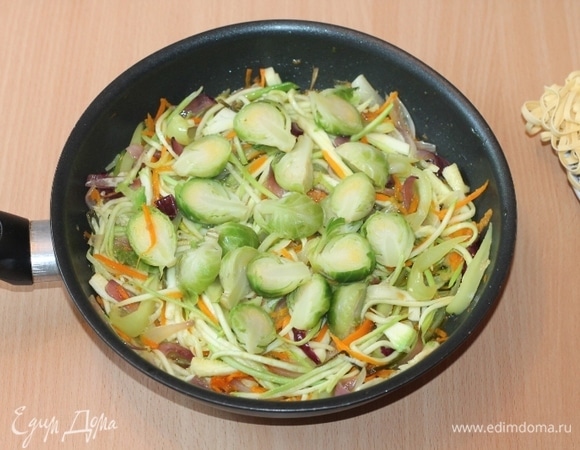 Брюссельскую капусту отварим в подсоленной воде. Затем воду сольем, кочанчики разрежем на 2 части и отправим в сковороду к овощам. Быстро обжариваем овощи при высокой температуре. Добавляем соевый соус, молотый перец. Все перемешиваем и тушим овощи еще пару минут. Вместо соли у меня соевый соус «легкий».