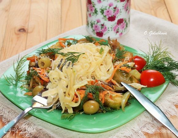 Готовую лапшу перекладываем в подогретое блюдо с овощами. Посыпаем веточками зелени и тертым сыром. Украшаем оливками. Приятного аппетита!