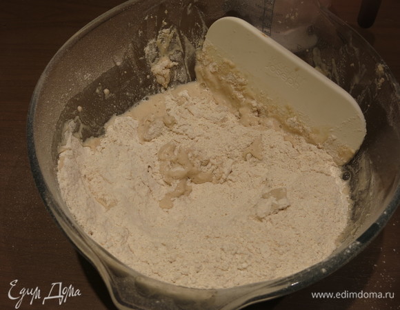 Начинаем вмешивать воду в муку круговыми движениями с помощью скребка.