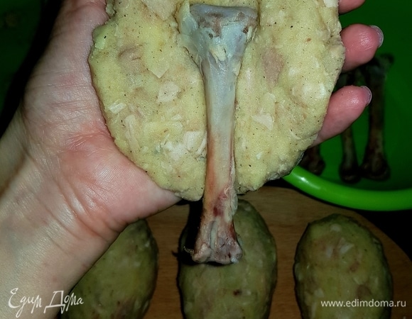 У меня 8 косточек от голени, я визуально разделила фарш на 8 частей. Берем часть фарша, формируем лепешку, в середину кладем косточку и формируем на ней форму голени.