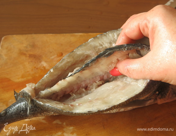 Подготовим рыбу. Очищаем чешую. Делаем два надреза вдоль хребта, отрезаем кость у головы и хвоста. Потрошим, не разрезая брюшко.