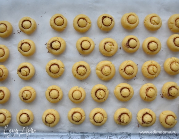 Из охлажденного теста скатать шарики. Необязательно, чтобы они были одного размера. Из данного количества теста получается 40–41 шт. Для формирования грибочков можно использовать любое подручное средство, например горлышко от бутылки или пробку. Опустить ее в какао-порошок и надавить на середину каждого шарика из теста. Выпекать в разогретой до 170–180°C духовке 15–20 минут.