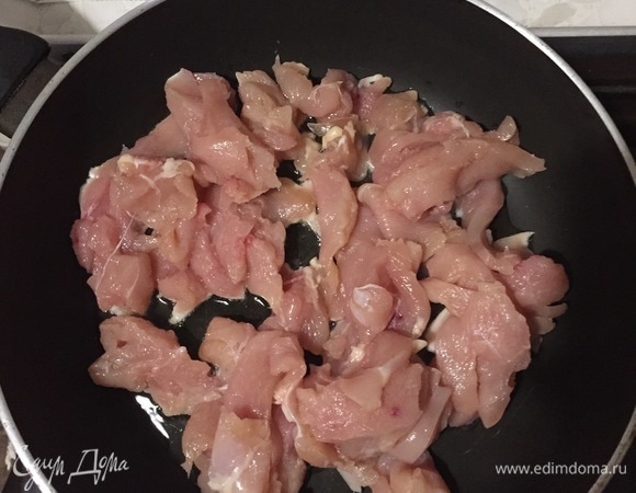 Нарезаем куриное филе на тонкие полоски, обжариваем на небольшом количестве масла до момента, когда мясо станет белым.